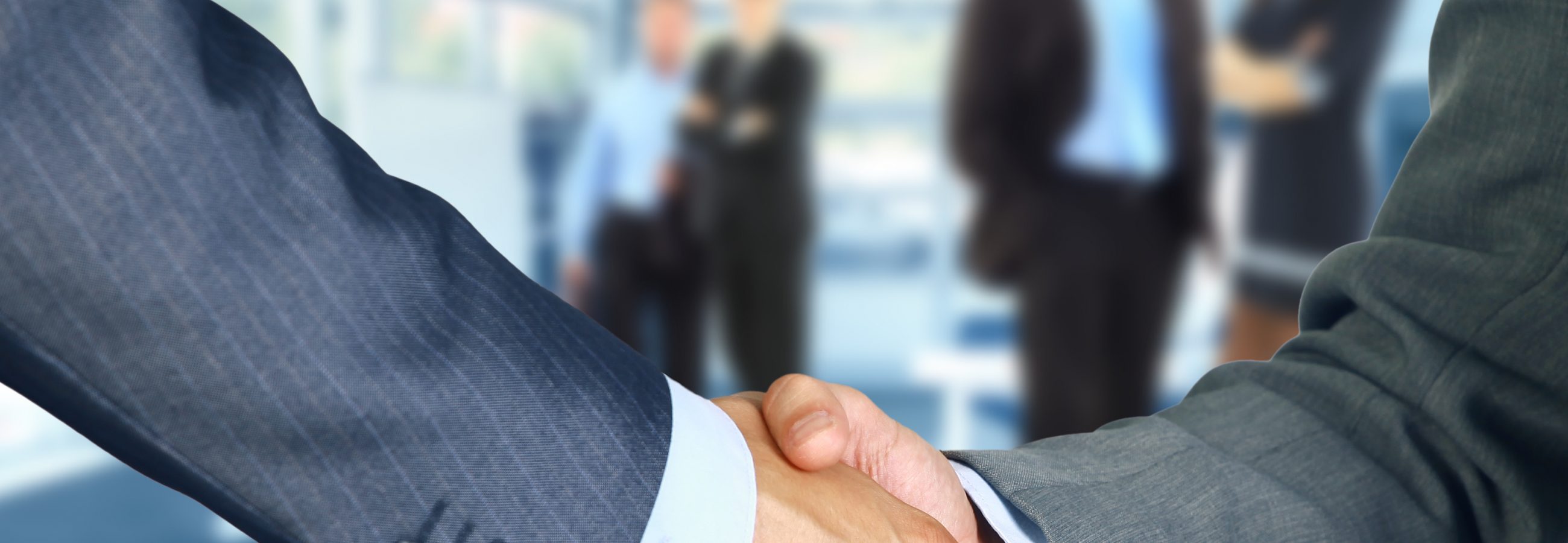 Business associates shaking hands in office